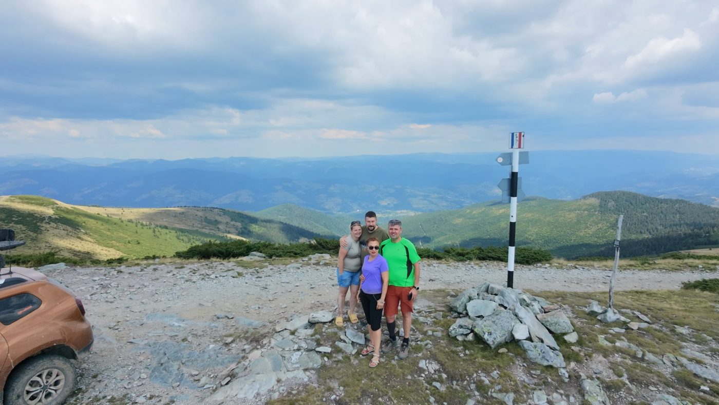 Andy and Elena with Radu and Violeta on Bihor Peak, wide green mountains behind them