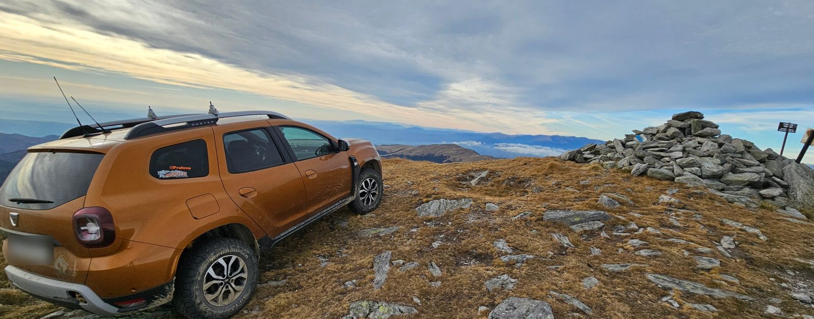 Our car parked beside the stone cairn on Leaota summit, with clouds over distant ridges